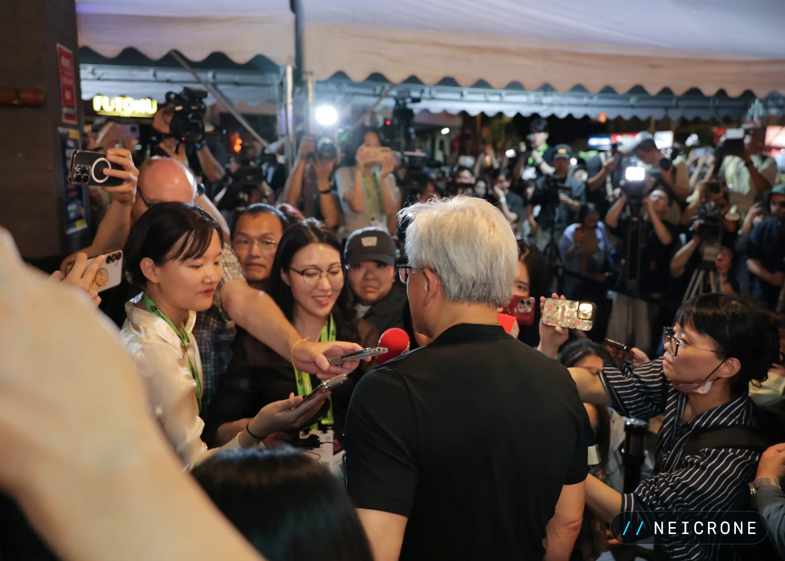 Jensen Huang surrounded by press and cameras at night