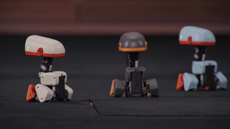 Three physical Microduck robots on the keynote stage