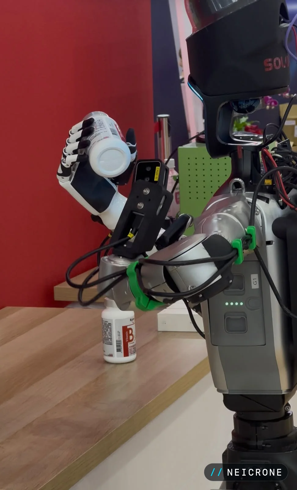 Humanoid robot grasping a bottle with a five-fingered hand