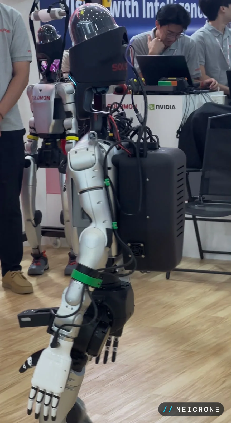 Side profile of a humanoid robot with cabling and a backpack compute unit